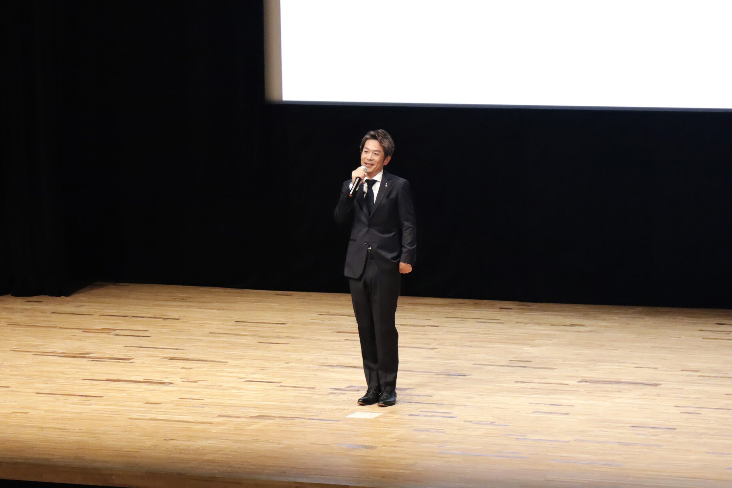 第42回日本小児臨床アレルギー学会学術大会のステージで特別講演を行う清水健。大会テーマ「つながる医療、つなぐ未来」のもと開催された講演会の様子。