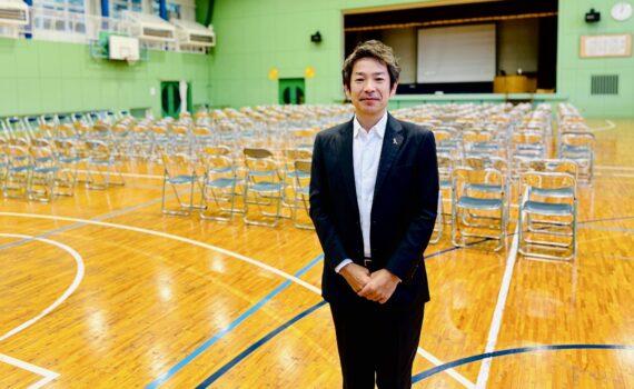 徳島県鳴門市立大麻中学校の体育館で開催された教育講演会。講師を務めるフリーアナウンサー清水健と、講演会会場の様子