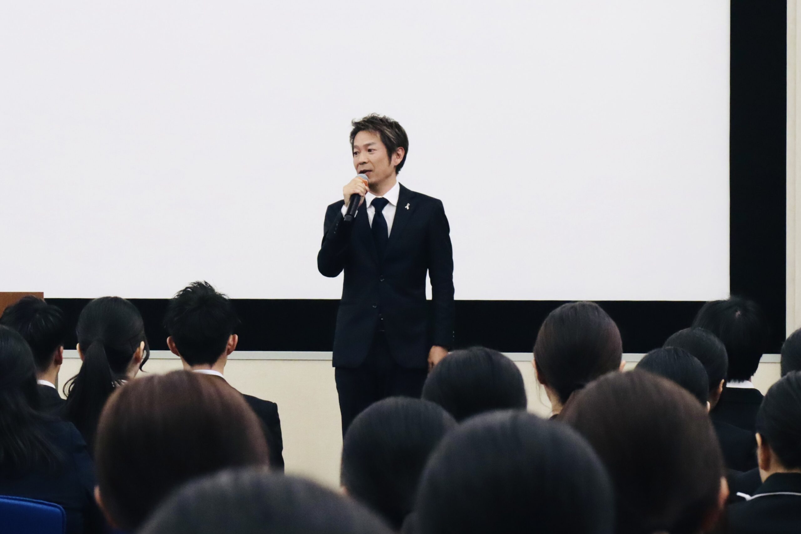 2027卒の医療職・介護職合同内定式で内定者を前に講演する清水健